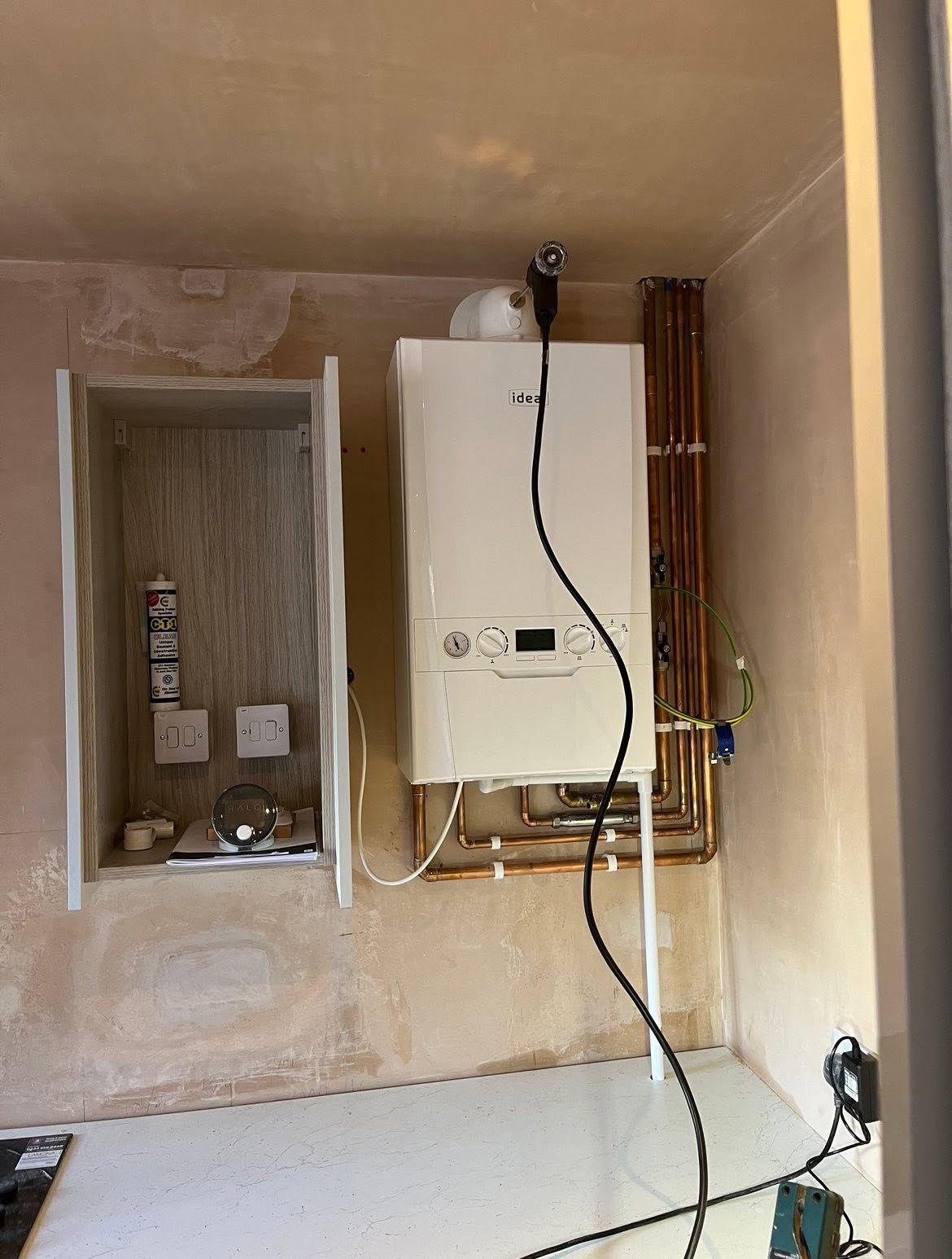 Gas engineer completing a modern combi boiler installation in a Cambridge home
