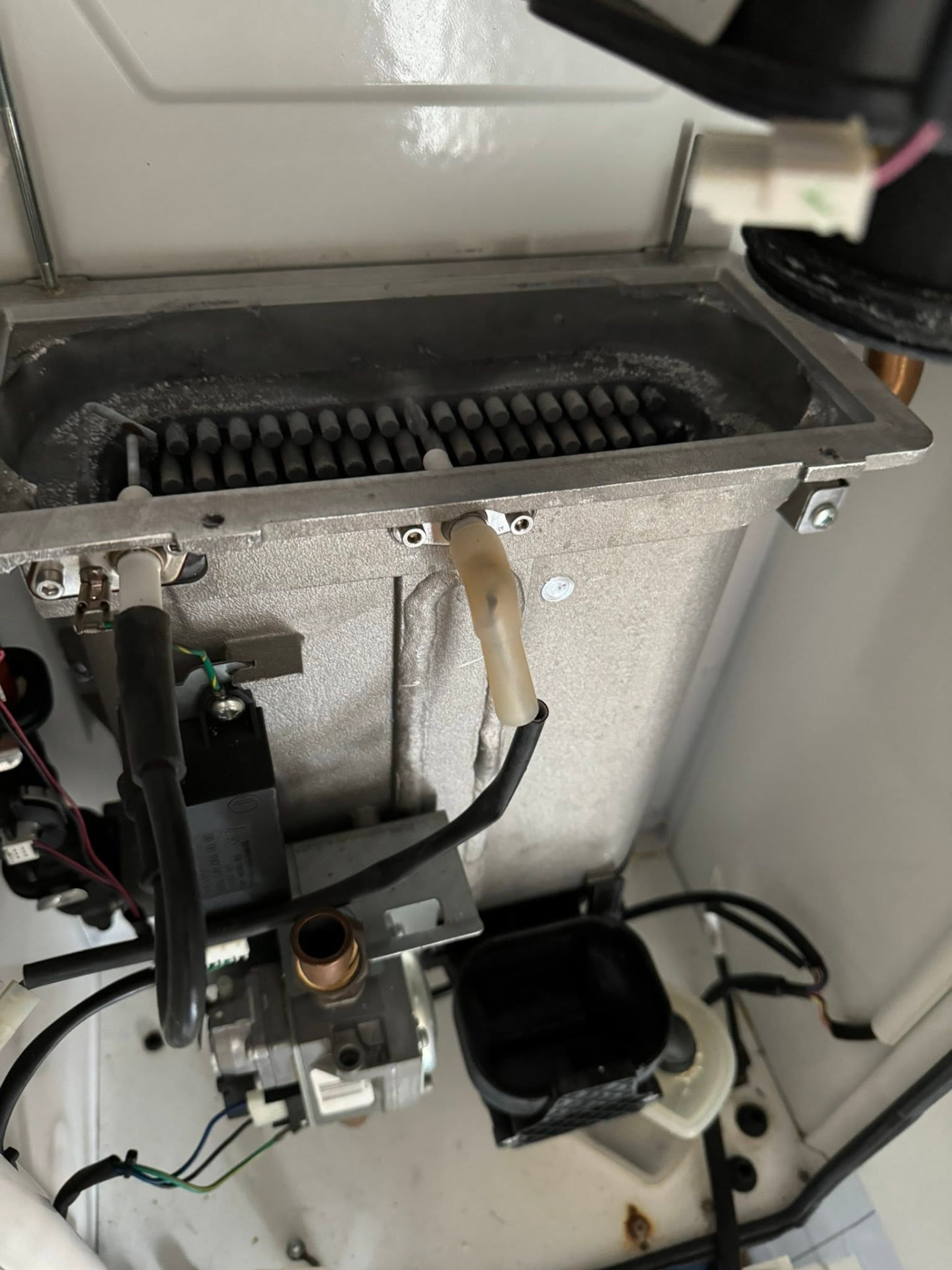 Boiler burner and gas valve exposed during an annual boiler service